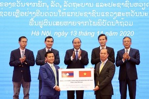 Deputy Minister of Foreign Affairs Nguyen Quoc Dung (R) hands over the token of the relief aid of 1,000 tonnes of rice from the Vietnamese Government to Lao Deputy Ambassador to Vietnam Chanthaphone Khammanichanh (Photo: VNA)
