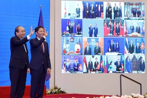 Vietnamese Prime Minister Nguyen Xuan Phuc (left) and Minister of Industry and Trade Tran Tuan Anh, together with leaders of other RCEP member countries, witness the pact signing via videoconference on November 15 (Photo: VNA)