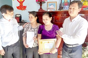 Pham Thi Mai ( purple) receives the medal (Photo: SGGP)