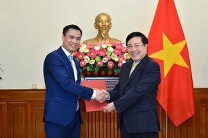 Deputy Prime Minister and Foreign Minister Pham Binh Minh (right) presents the decision to Deputy Foreign Minister Dang Hoang Giang. (Photo: Baochinhphu.vn)