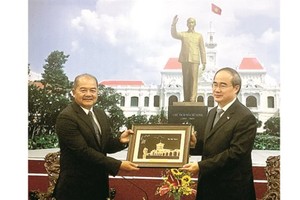 Politburo member, Secretary of Ho Chi Minh City Party Committee Nguyen Thien Nhan offers a souvenir for Secretary of the Lao Party Central Committee Kikeo Khaykhamphithoune