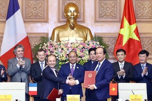 Prime Minister Nguyen Xuan Phuc (C) witnesses the signing ceremony between the Government Office of Vietnam and the French Development Agency (AFD) in e-government development cooperation (Photo: VNA)