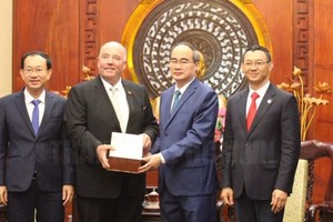 Secretary of the Party Committee of Ho Chi Minh City Nguyen Thien Nhan offers a souvenir to  former Ambassador of Germany to Vietnam Rolf Schulze