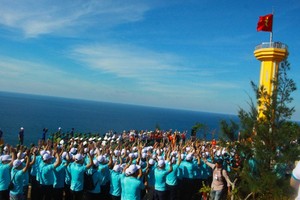 Flag raising ceremony takes place at Thoi Loi peak (Photo: Nguyen Trang)