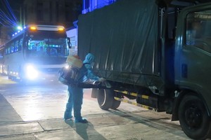 A worker sprays disinfectant on a vehicle entering a concentrated quarantine facility (Photo: VNA)