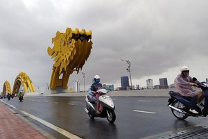 Vehicles move on Rong (Dragon) Brdige in Da Nang on November 14. The central city has recorded heavy rains and strong winds since the noon of November 14 as Storm Vamco is nearing (Photo: VNA)