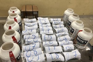 Suspected drugs are packaged and hidden inside nutrition supplement cans together with a number of candy shipment.