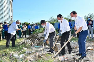 Các đồng chí lãnh đạo quận 7 tham gia dọn vệ sinh môi trường. Ảnh: VIỆT DŨNG