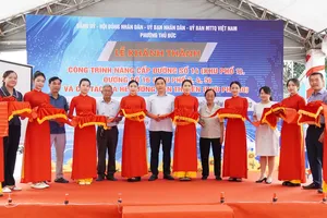Nghi thức cắt băng khánh thành các công trình cải tạo, nâng cấp đường, vỉa hè trên địa bàn. Ảnh: THU HƯỜNG