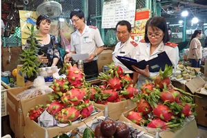 Đoàn kiểm tra nguồn gốc xuất xứ trái cây nhập vào chợ. Ảnh: HOÀNG HÙNG