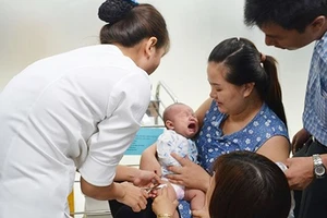 Nhân viên y tế tiêm vaccine cho trẻ em