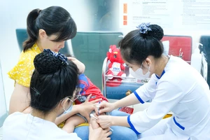 Phụ huynh đưa con đến tiêm chủng vaccine viêm màng não mô cầu tại VNVC