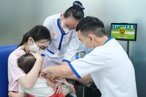 Nhân viên y tế đang tiêm vaccine cho trẻ