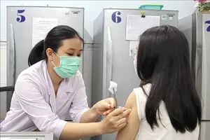 Nhân viên y tế tiêm vaccine cho trẻ