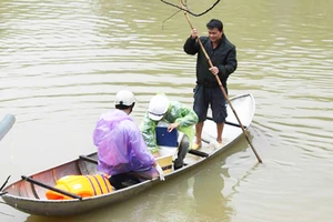 Tiến hành lấy mẫu nước tại khu vực xuất hiện cá và vịt chết. Ảnh: NGUYỄN TRANG