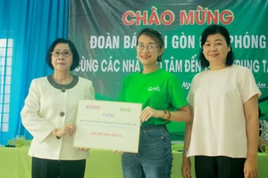 Bà Lý Việt Trung, Phó Tổng Biên tập Báo SGGP (bên phải) cùng đại diện Công ty TNHH Grab trao hỗ trợ 100 triệu đồng cho bà Nguyễn Thị Thu Hà, Giám đốc Trung tâm Võ Hồng Sơn. Ảnh: NGUYỄN TRANG