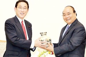 PM Nguyen Xuan Phuc ( R) presents a souvenir to Mr. Fumio Kishida