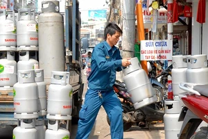 Đưa gas vào một cửa hàng cung ứng cho người dân. Ảnh: CAO THĂNG