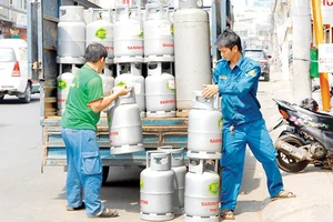 Đưa gas vào một cửa hàng cung ứng cho người dân. Ảnh: CAO THĂNG