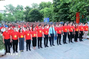 Các đại biểu, thanh niên và đoàn viên thực hiện nghi lễ chào cờ, sáng 16-8. Ảnh: TTXVN