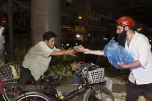 導演喬丹‧沃格‧羅伯茨給本市無家可歸者分發飯菜和奶品。