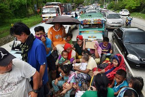 圖為菲政府與地方武裝合作救援被困平民轉移到安全地帶。（圖源：AFP）