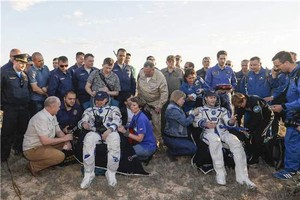 法國宇航員托馬斯·佩斯凱（前右三）和俄羅斯宇航員奧列格·諾維茨基（前左三）安全著陸後坐在椅子上。（圖源：互聯網）