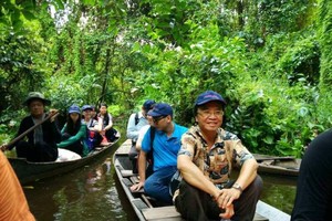 文友乘坐小艇參觀根據地。(圖源：曉東)