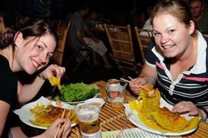 外國遊客在品嚐我國美食。（圖源：互聯網）