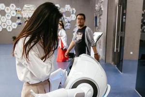 “雲朵”智能互動機器人在擁抱一位觀眾。它能與人對話交流，還能表演唱歌跳舞。（圖源：互聯網）