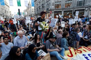 數百名示威者在倫敦肯辛頓和切爾西市政廳外舉行抗議，要求政府盡快查明火災真相。（圖源：路透社）