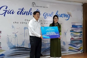 阮明日社長向陳凰鳳女士(右) 贈送越文書籍。（圖源：互聯網）