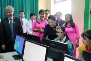 國會主席阮氏金銀向勞科村小學師生贈送電腦。(圖源：VOV)