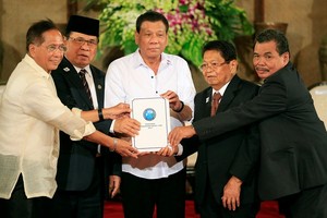 菲律賓最大叛軍組織“摩伊解”的代表和政府官員到馬尼拉總統府，將“邦薩摩洛基本法”新草案呈給總統杜特爾特（中）。（圖源：路透社）