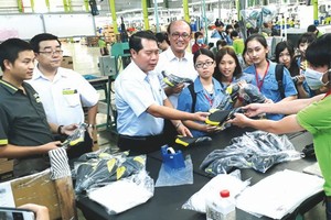 蔡文瑞董事長(左三)帶領見習生參觀生產線。(圖源：燕農)