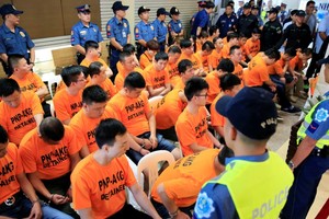 菲律賓全國警察總長羅薩（右）週四和43名穿著橙色上衣的嫌犯，一起出席記者會。(圖源：路透社)