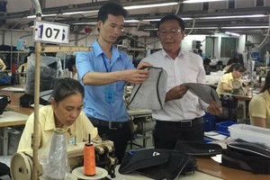 黎文武（左）正在檢查產品。