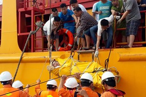 船員們一起將中風船員轉移到SAR 413專用救護船。（圖源：VOV）