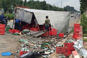 運載啤酒卡車失控側翻，導致上百箱啤酒跌落滿路，民眾幫助司機撿拾啤酒並清理現場，確保路人交通安全。（圖源：）
