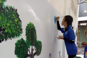 志願青年在巷子的牆壁繪上關注環保的圖畫。（圖源：心雨）