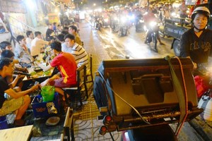 在舊邑郡范文同街上，街頭賣唱者使用大功率擴音器播放以招徠 路人關注。