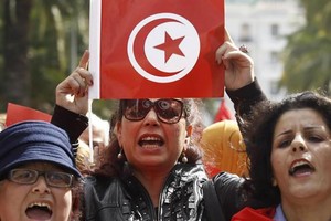 一名突尼斯婦女手持該國國旗進行慶祝。（圖源：互聯網）