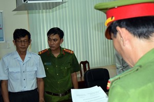 公安在向嫌犯陳鴻源(左)宣讀逮捕令。（圖源：T.T）