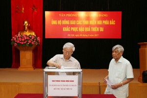 阮富仲總書記給災民捐款。（圖源：越通社）