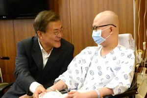 8月9日，文在寅（左）訪問位於首爾瑞草區的首爾聖母醫院，並與病人親切交談。（圖片來源：韓聯社）