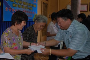 溫陵會館理事長張子諒向長者贈送扶助金。