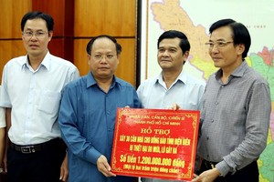 市委常務副書記畢成剛(左二)將12億元的救助金交予奠邊省祖國陣線委員會常務主席陳文山。（圖源：越通社）