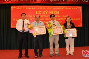 市內政處主任陳世琉(左)向各級黨委代表頒授黨齡紀念章。（圖源：VOH）