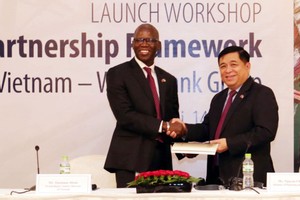 世界銀行駐越南國家首席代表奧斯曼‧迪奧主任將2017-2022年階段越南國家合作夥伴框架文件交予計劃與投資部部長阮志勇。（圖源：陳越）