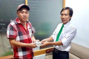 乘客蘇英文(左)從司機手上接回所遺忘的財物。（圖源：ML）